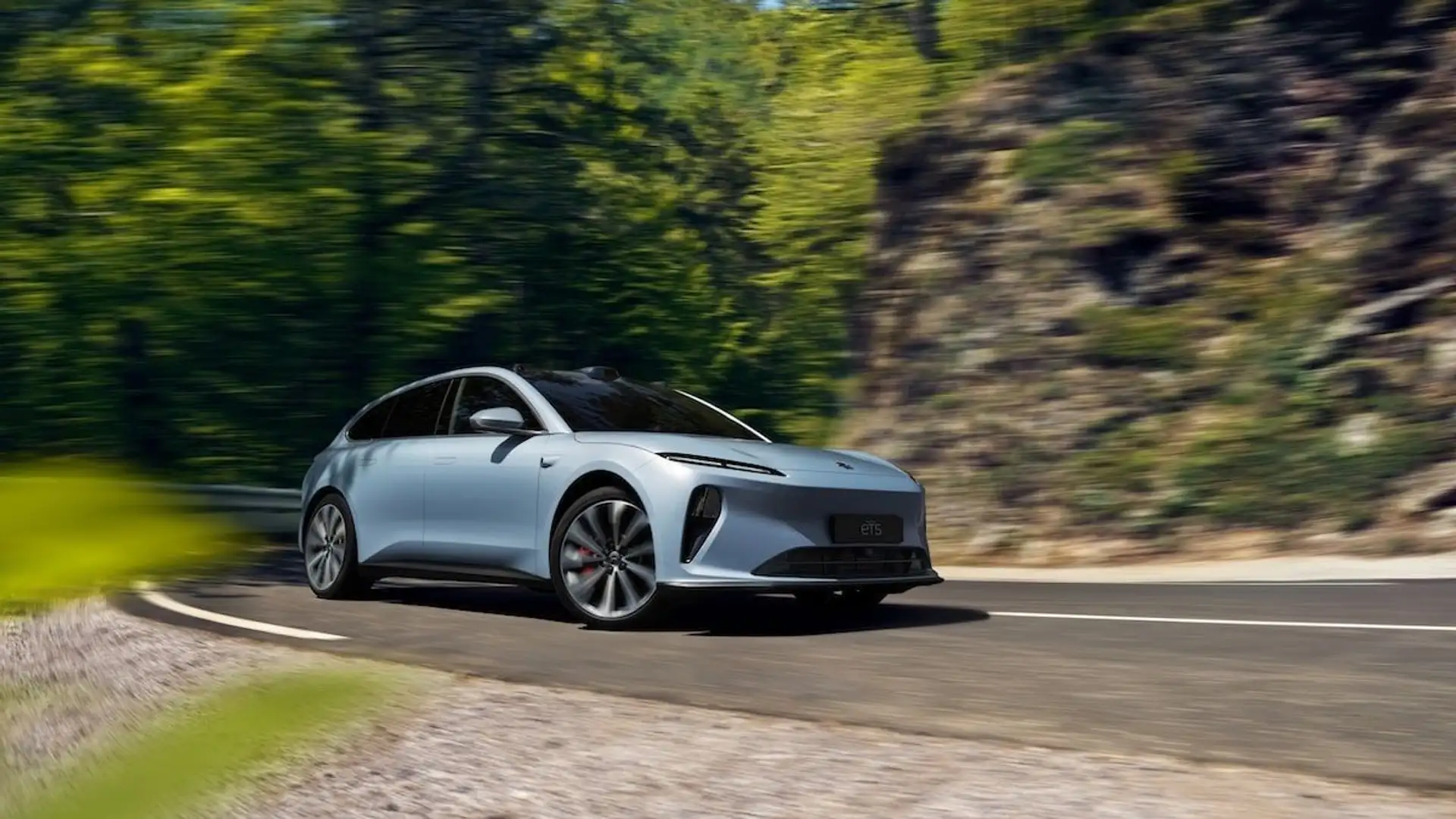 Ein NIO ET5 Touring auf einer Landstraße vom Fahrbahnrand fotografiert.